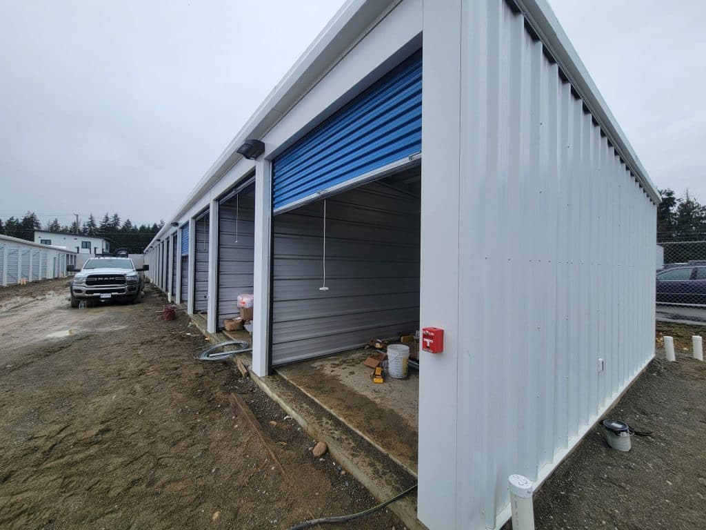 Row of outdoor drive-up storage units with blue roll-up doors at All Access Storage Parksville.