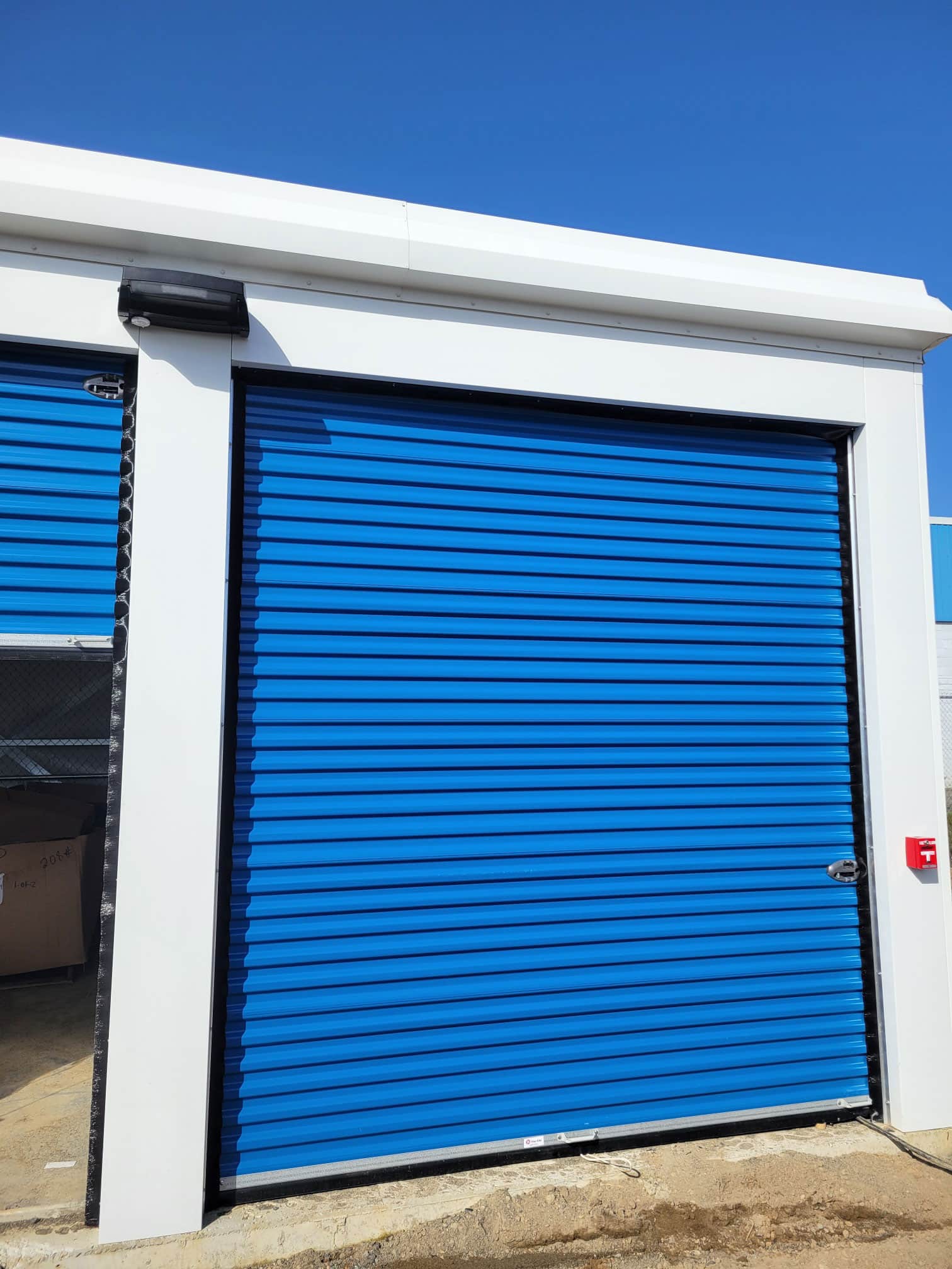 Row of outdoor drive-up storage units with blue roll-up doors at All Access Storage Parksville.