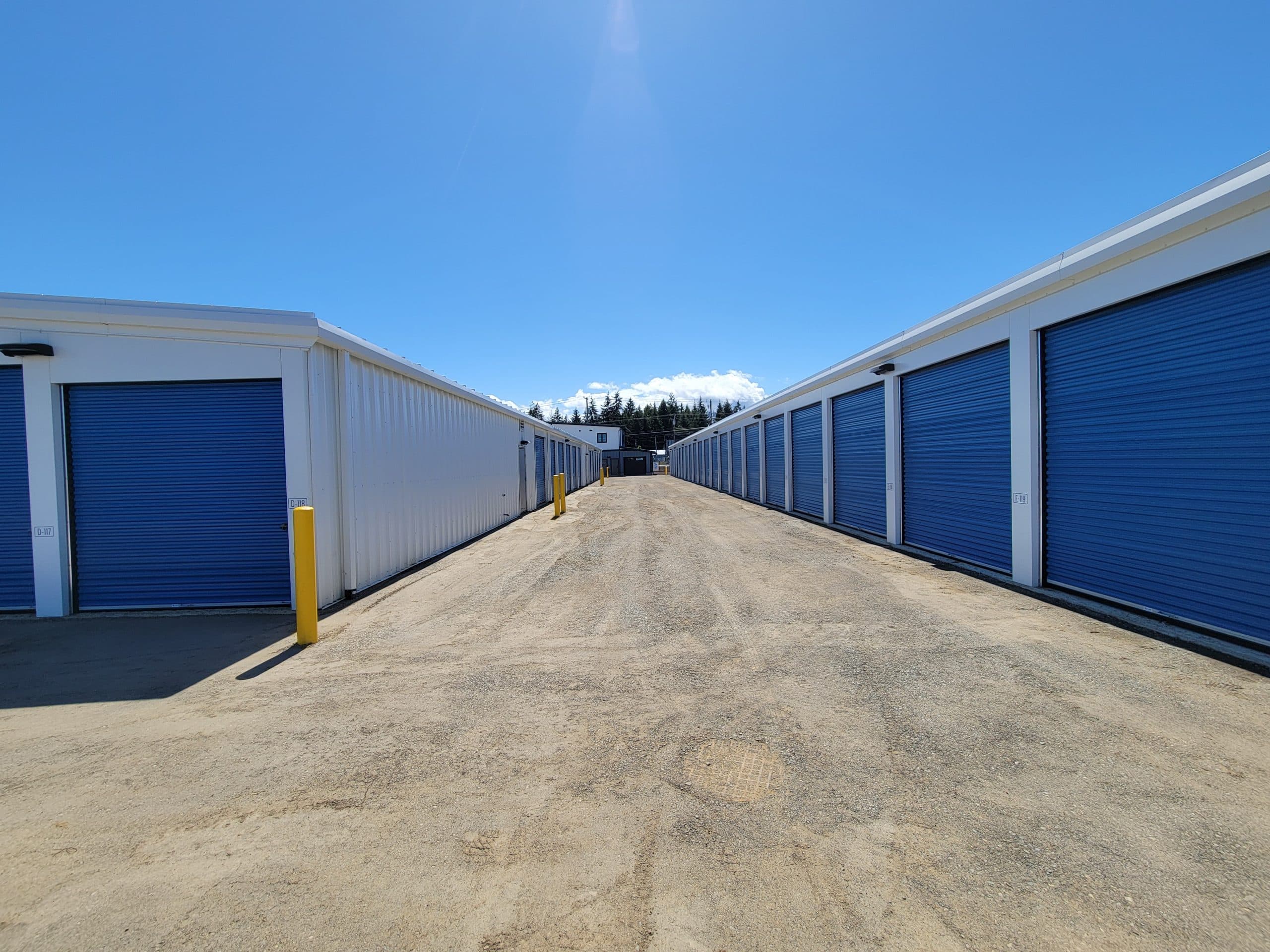 Row of outdoor drive-up storage units with blue roll-up doors at All Access Storage Parksville.