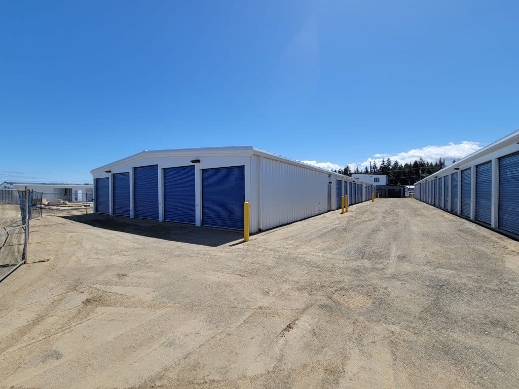 Row of outdoor drive-up storage units with blue roll-up doors at All Access Storage Parksville.