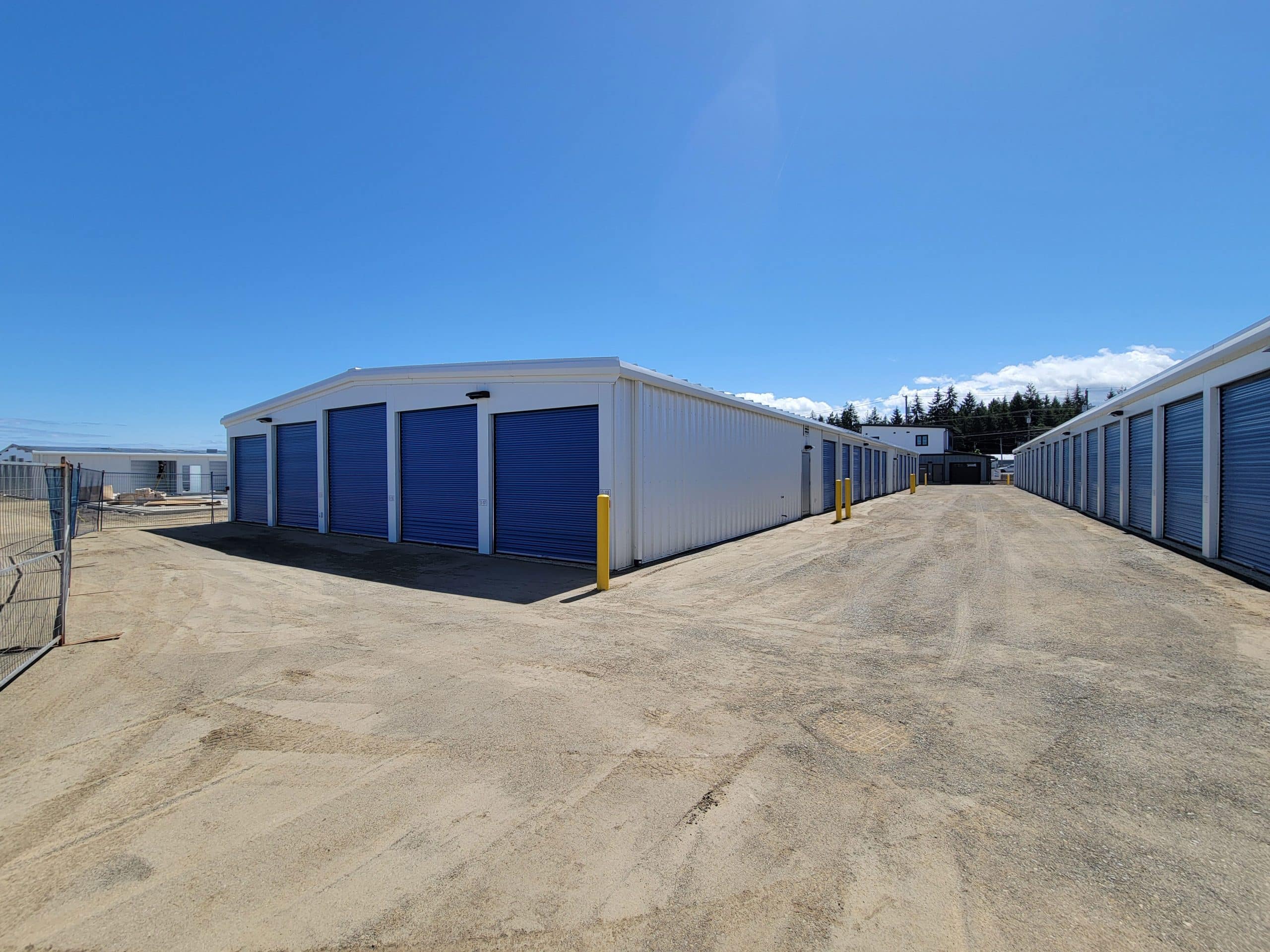 Row of outdoor drive-up storage units with blue roll-up doors at All Access Storage Parksville.